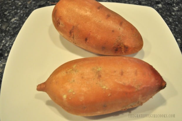 The sweet potatoes are washed, dried, and pieced with a fork before cooking.