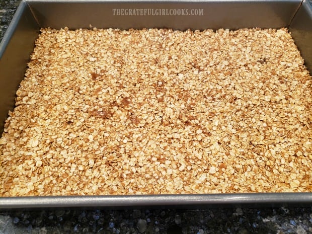 The mixture is packed down firmly into the pan before going into the oven.