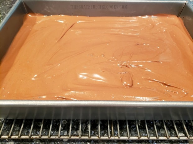 Frosting is spread over the top of the butterfinger bars, and then rests to firm up.