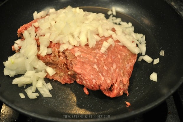 Ground beef and chopped onions are pan-seared until fully cooked.