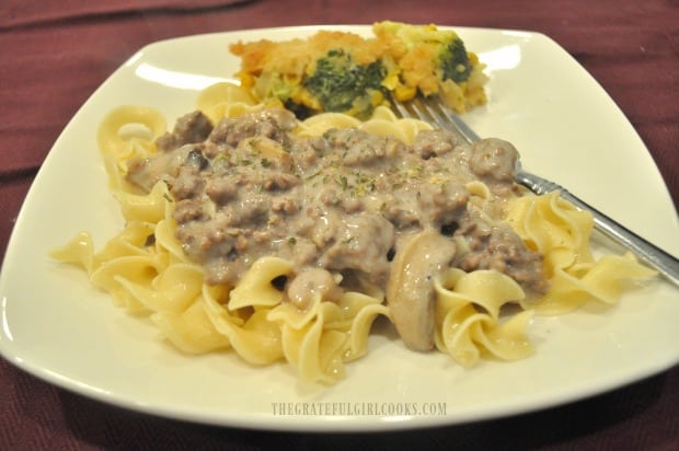 Hot, buttered egg noodles are topped with the ground beef stroganoff to serve.