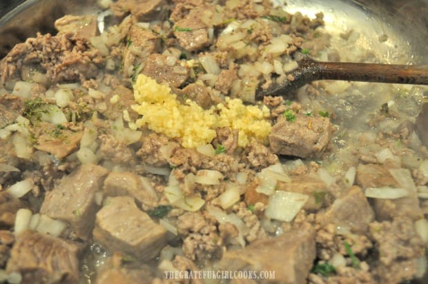 Minced garlic is added to the browned meat mixture.