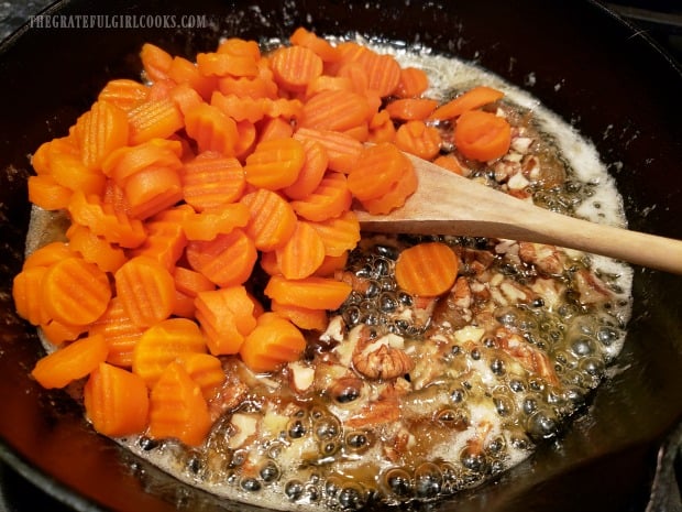 The cooked carrots are now added to the orange glaze in skillet.