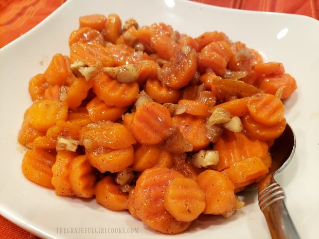 A close up view of a bowl of orange glazed carrots, ready to eat!