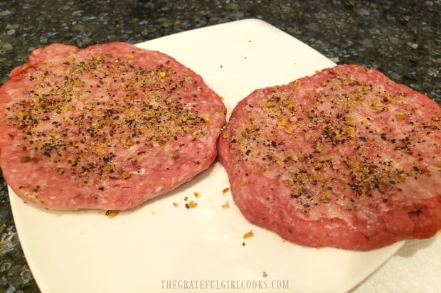 Hamburger patties are seasoned with spices, butter, and liquid smoke before cooking.