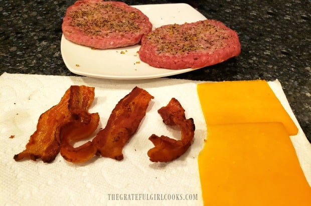 Pre-cooked bacon and cheddar cheese slices ready to add to cooked burgers.