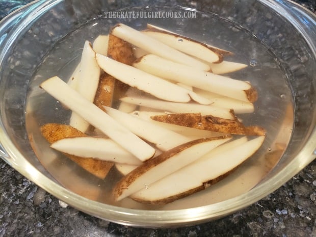 French fries are soaked in water for 30 minutes before draining and cooking.