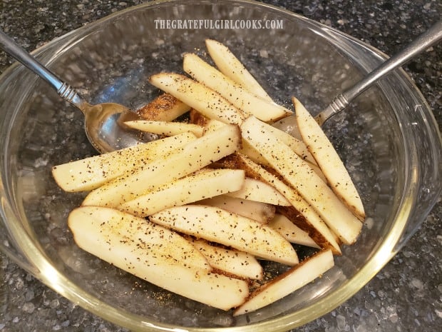 Fries are seasoned with oil, salt and pepper before cooking.