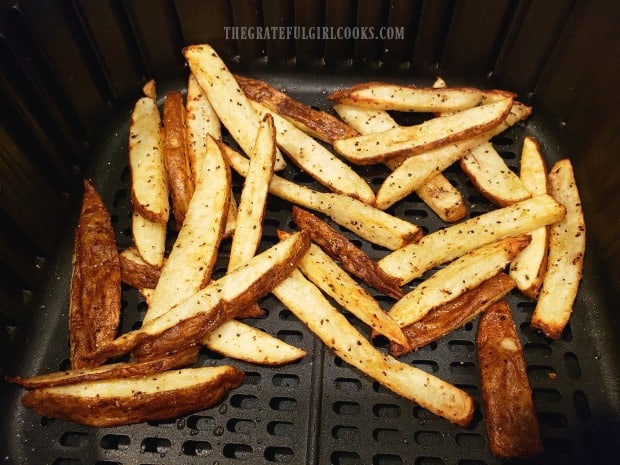 Air fryer french fries in basket of machine after cooking.