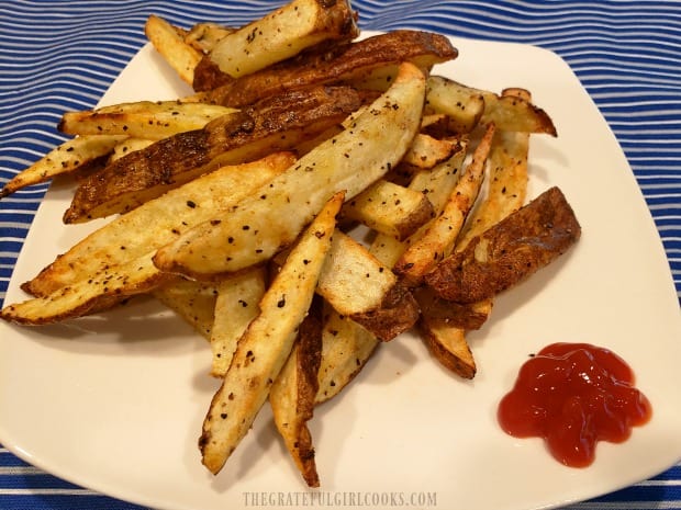 A plate full of air fryer french fries, and dipping ketchup on the side.