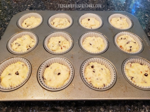 The 12 muffin cup holders are each filled 3/4 of the way with batter.