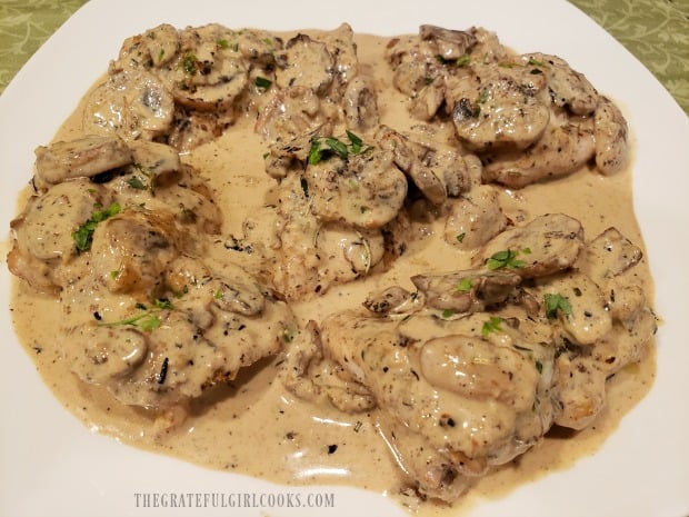 Creamy Mushroom Chicken Thighs are served on a white platter.