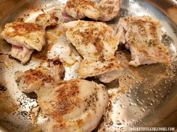 The chicken thighs are cooked on both sides until golden brown.