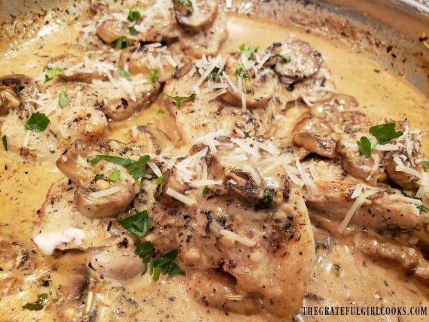 Grated Parmesan cheese and parsley are added to garnish creamy mushroom chicken thighs.