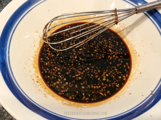 Ingredients for homemade teriyaki marinade are whisked together in a bowl.