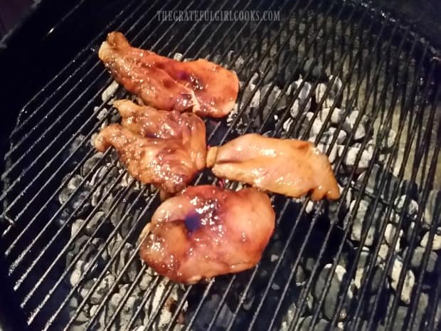Teriyaki chicken breasts cooking on a Weber BBQ.