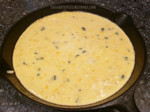 Batter for jalapeño cheddar cornbread is poured into a heated skillet before baking..