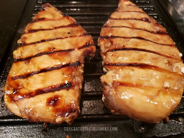 The marinated chicken breasts are grilled on both sides until done.