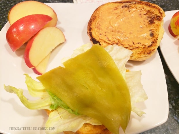 Lettuce and a whole green chile is added to the toasted buns with sauce.