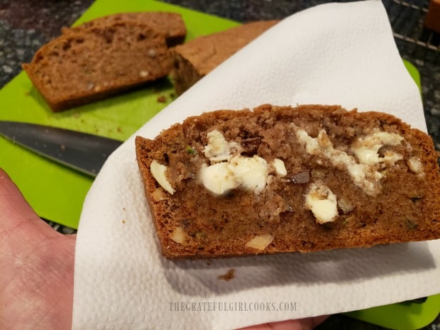 One slice of warm zucchini nut bread, smeared with butter, and ready to eat!