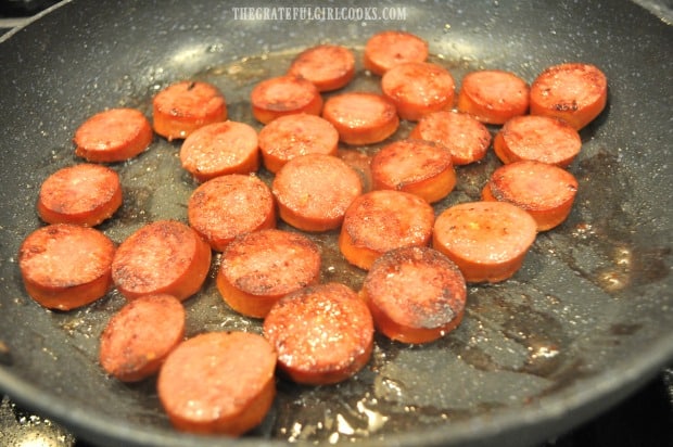 After the bottom browns on the kielbasa, the slices are turned to other side to finish cooking.