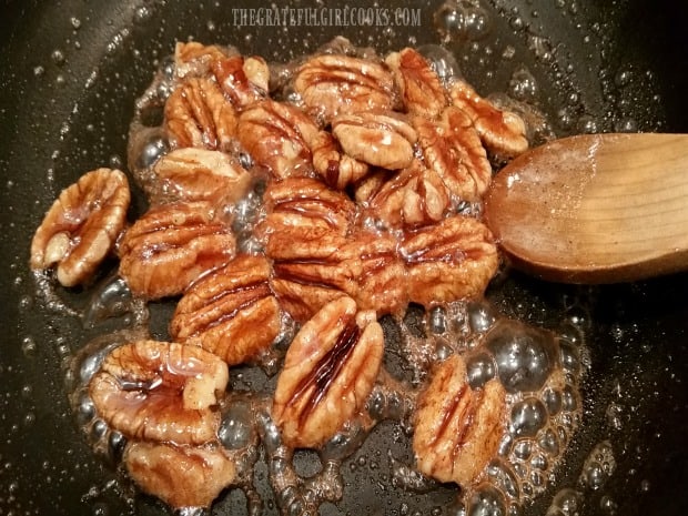 Pecan halves are cooked and candied with butter, cinnamon and brown sugar.