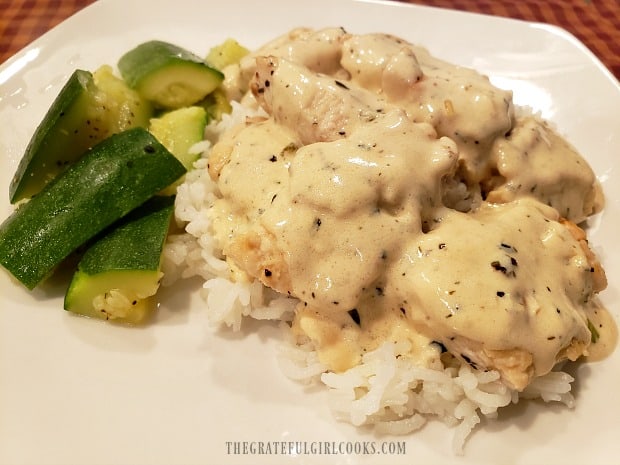 Thick creamy lemon sauce covers the pan-seared chicken pieces on top of rice.