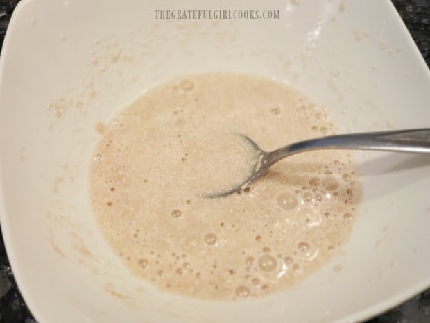 Yeast, sugar, and heated water are stirred together, and then let sit for 10 minutes.
