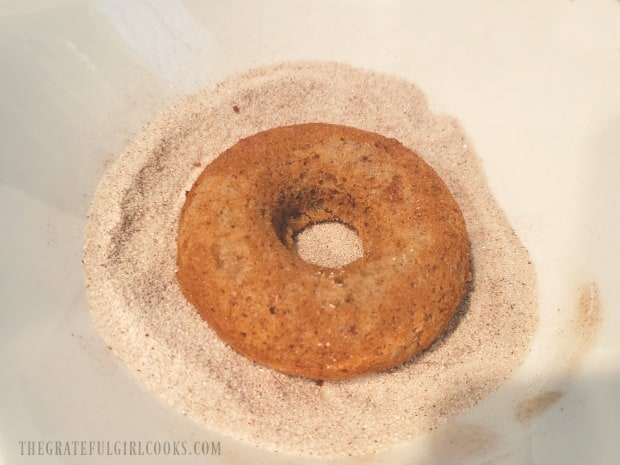The doughnut is placed, butter side down into cinnamon sugar mixture.