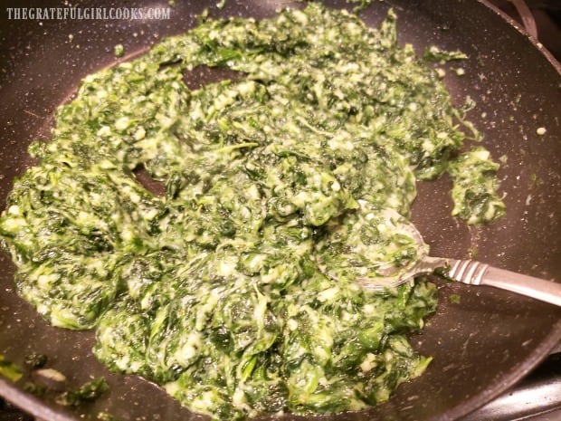Easy creamed spinach is cooked until it thickens, and is heated through.