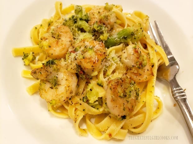 A close up of herbed shrimp broccoli pasta, with a fork on the side.