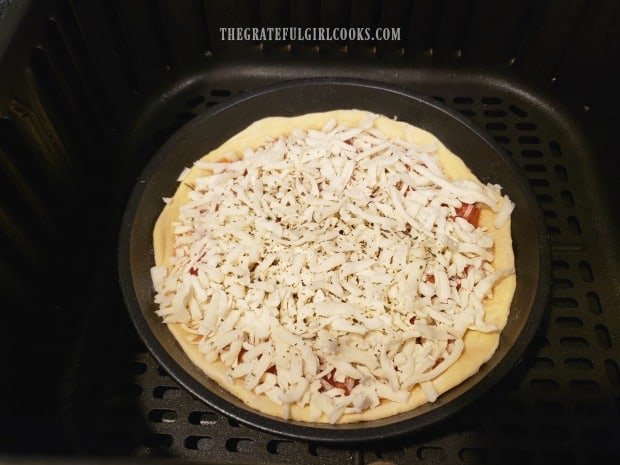 Cook the air fryer pizza for 5 minutes, before removing pizza from pan.