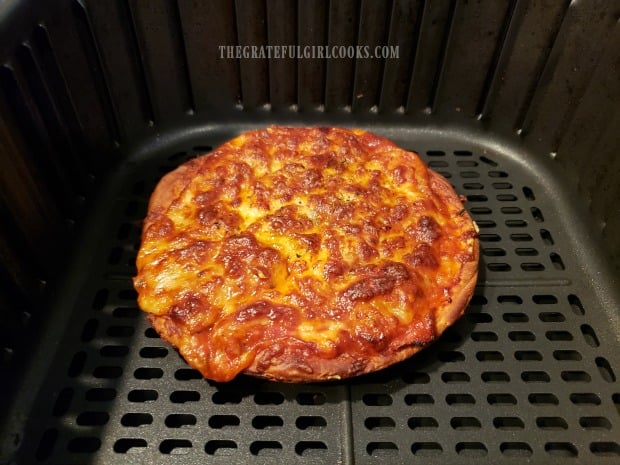 The pizza is removed from pan and finishes cooking in the air fryer.