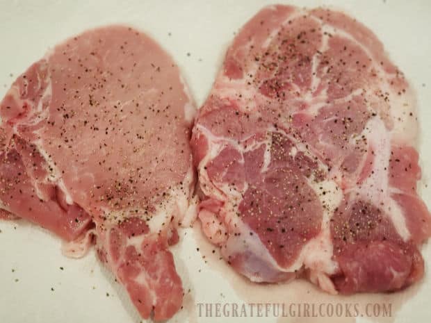 Pork chops are seasoned with salt and pepper on both sides before pan-searing.