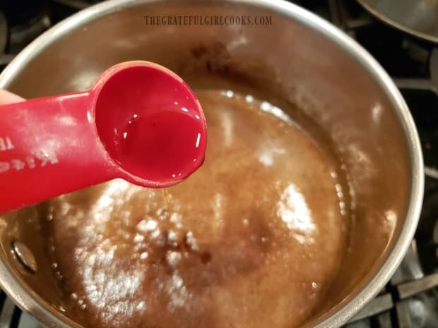 Vanilla extract is added to the butter and spice sauce in pan.