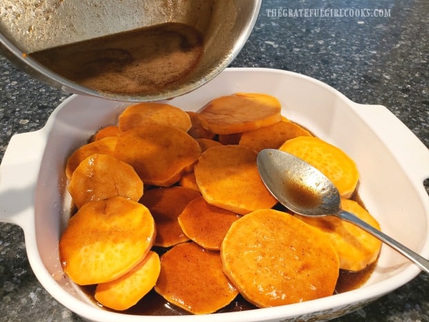 Sauce is poured over the sweet potato rounds, to coat before baking.