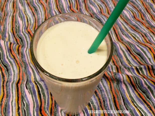 Here is a coconut pineapple smoothie, served with a straw.