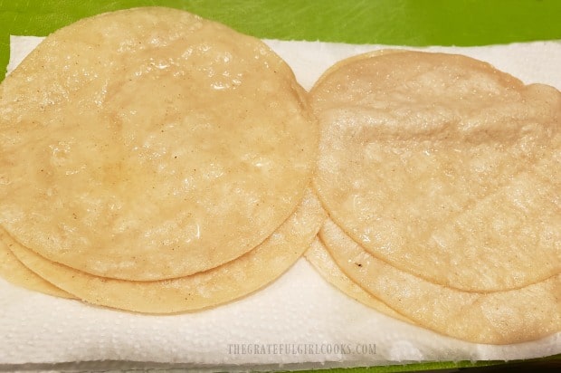 Quickly fried tortillas are blotted dry with paper towels before adding enchilada filling.