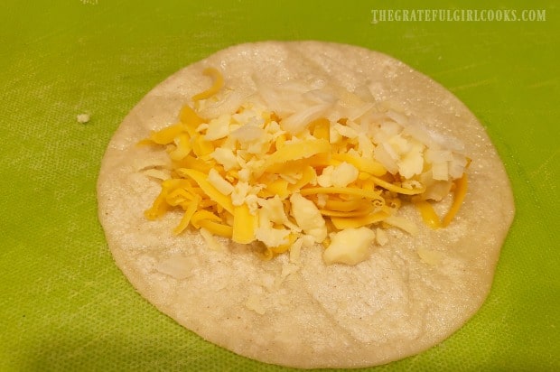 Each corn tortilla is filled with jack and cheddar cheese and chopped onions.