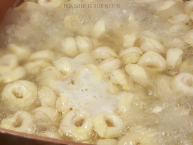 Cheese tortellini are cooked per package directions, and then drained.