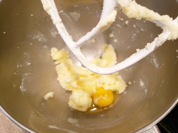 Butter and sugar are creamed using a mixer, and then an egg is added to batter.