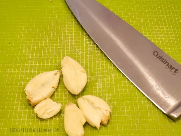 The garlic cloves have each been smashed with the knife to release the flavor.