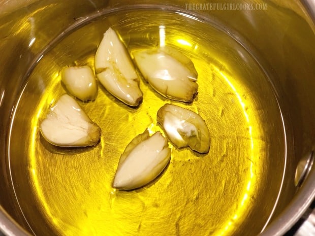 Cooking the smashed garlic cloves with olive oil.