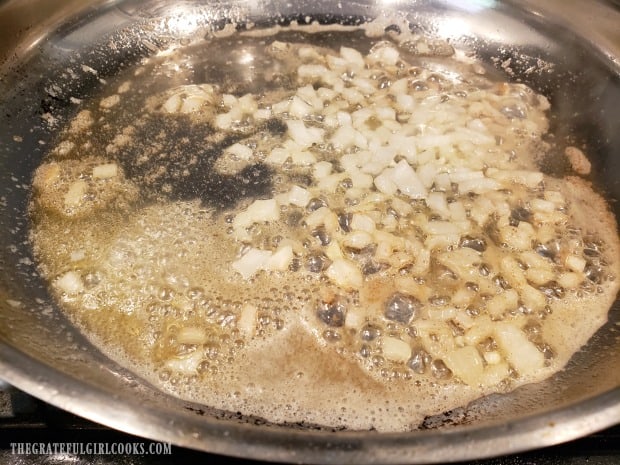 Chopped onions are cooked in olive oil and butter until softened.