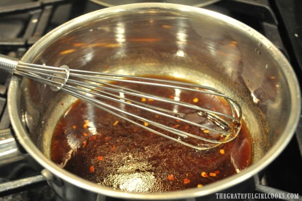 Ginger sesame salad dressing is whisked, then brought to a boil on the stove.