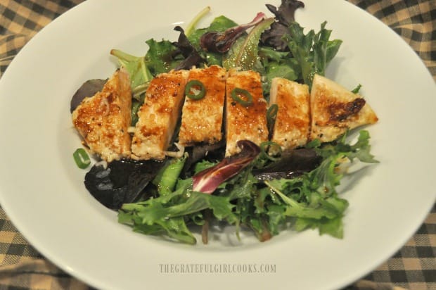 A main dish chicken salad in a bowl, topped with ginger sesame salad dressing.