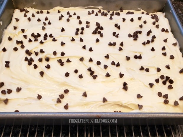 Frosting is spread on cooled banana bars, then garnished with chocolate chips.
