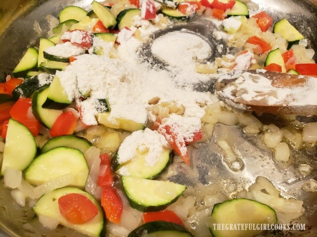 Flour is stirred into the veggies to help thicken sauce later.