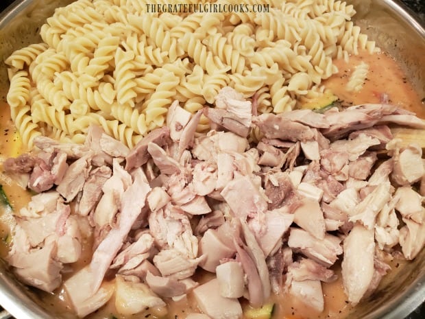 Cooked pasta and chicken are added to the creamy sauce.