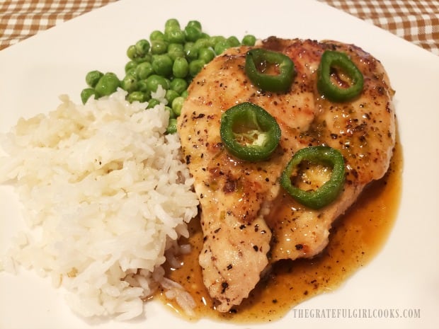 Easy chicken jalapeño, topped with sauce and sliced jalapenos, served with rice and peas..